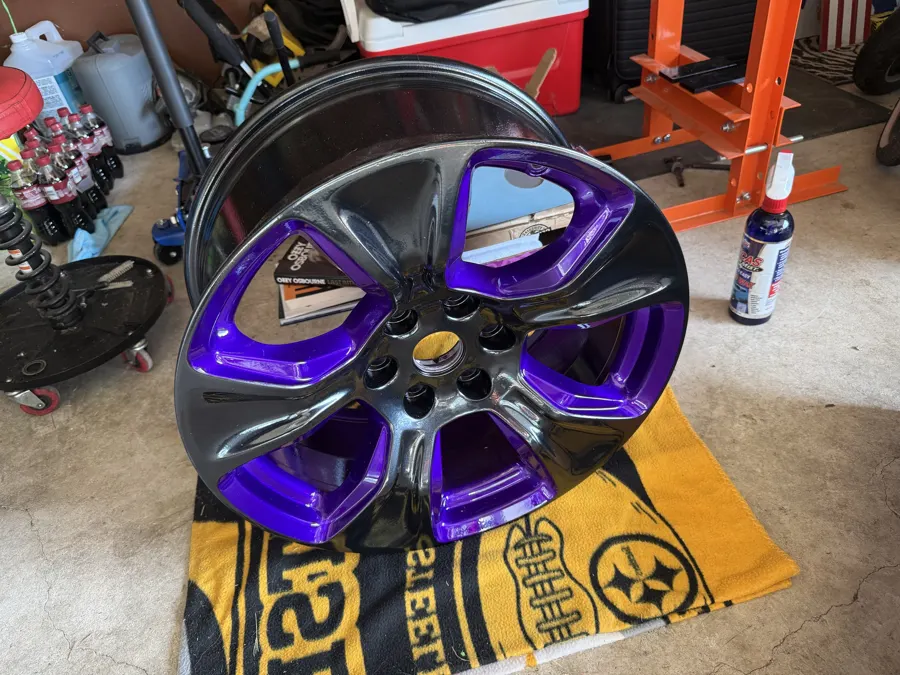 Car wheel powder coated in gloss black with candy purple face accents